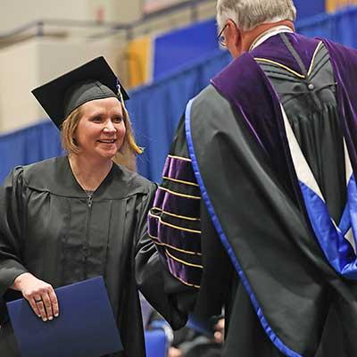 a student shakes the chancellors hand during graduation